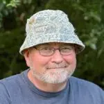 Image of a PawPaw. An older gentleman smiling at the camera while wearing a bucket hat.