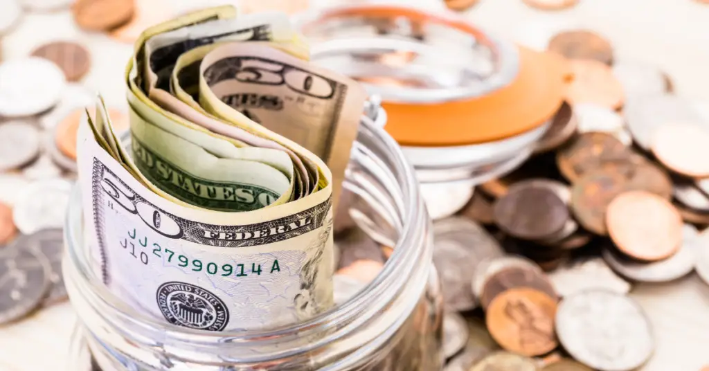 Jar with bills of money stuffed inside that represents savings.